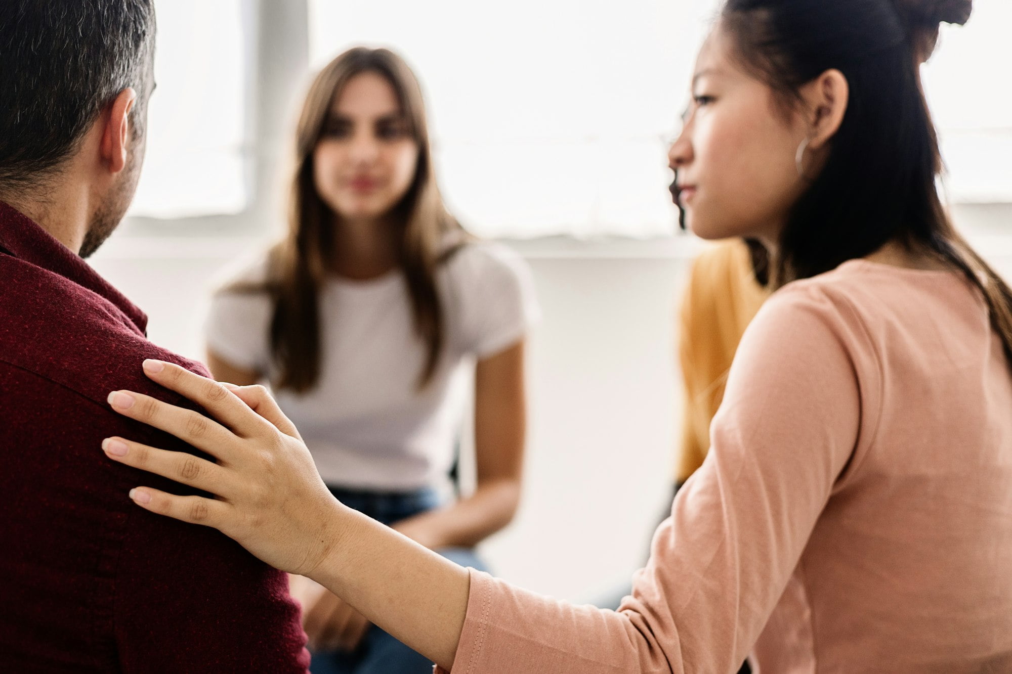 Diverse young teenage people receiving support during a therapy session.