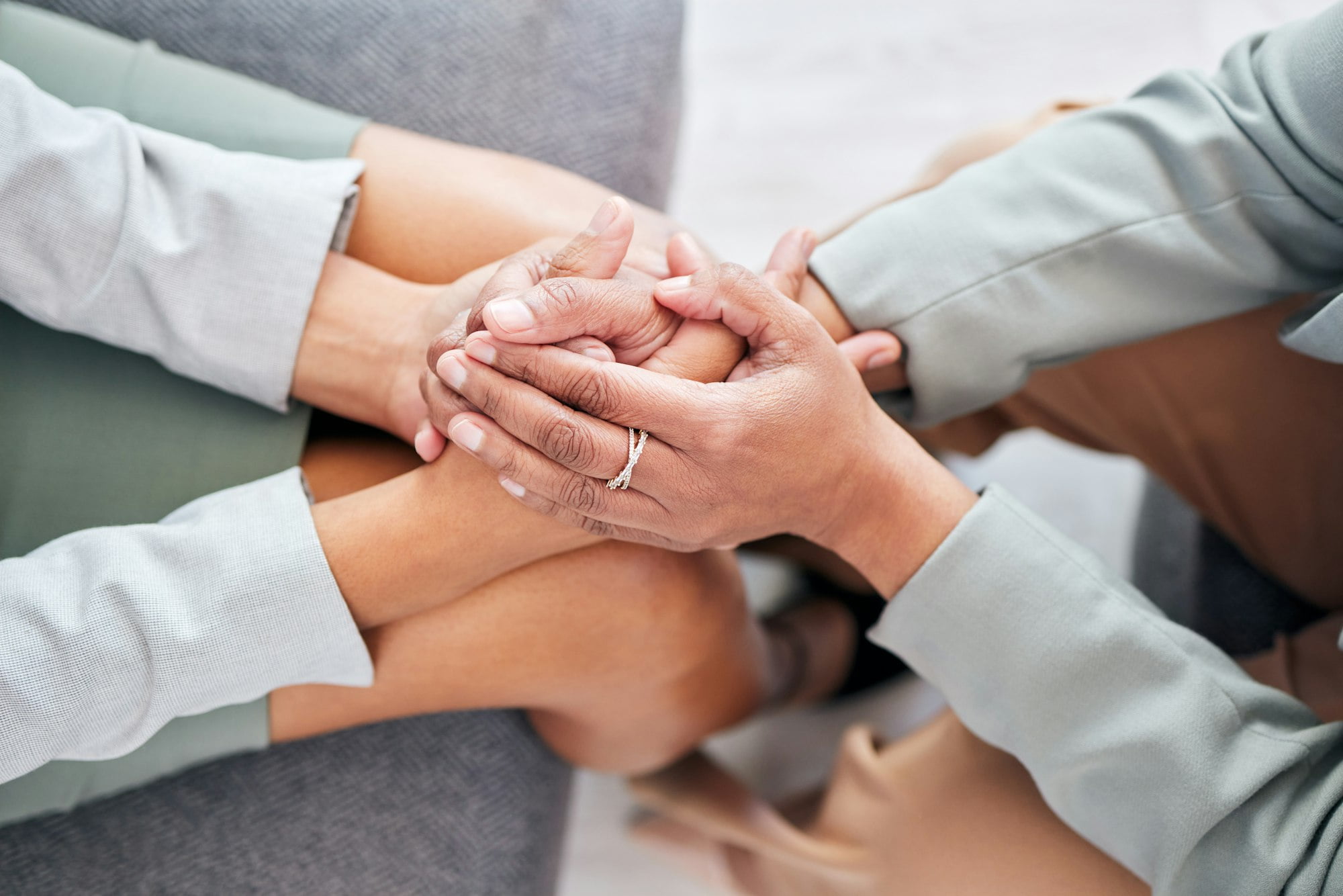 Women holding hands for therapy support, empathy and help with depression, mental health or trauma